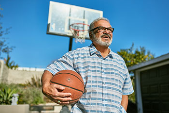 dad standing outside holding a basketball