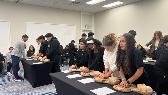 Students from Long Branch Middle School practice Hands-Only CPR.