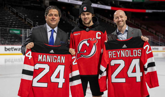 Displaying jerseys bearing the RWJBarnabas Health logo are Mark E. Manigan, President and Chief Executive Officer, RWJBH; Nico Hischier, Devils captain; and Jake Reynolds, President, New Jersey Devils and Prudential Center