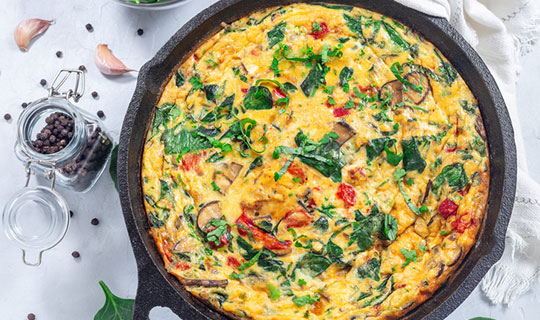 frittata with greens in a cast iron pan