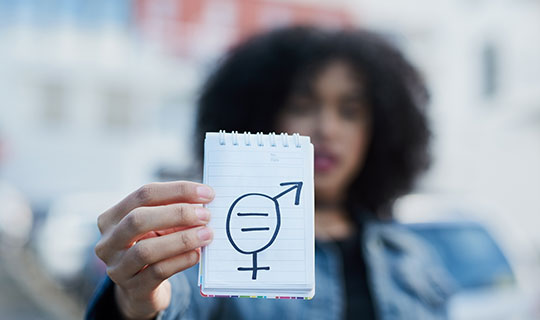 person holding notepad with gender equality symbol