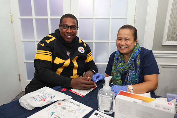 Attendee Anthony Tucker receives diabetes information during a glucose screening